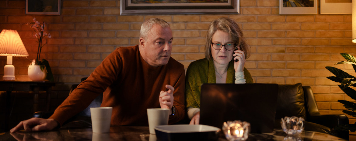 Et ægtepar sidder foran computer og bliver svindlet over telefonen