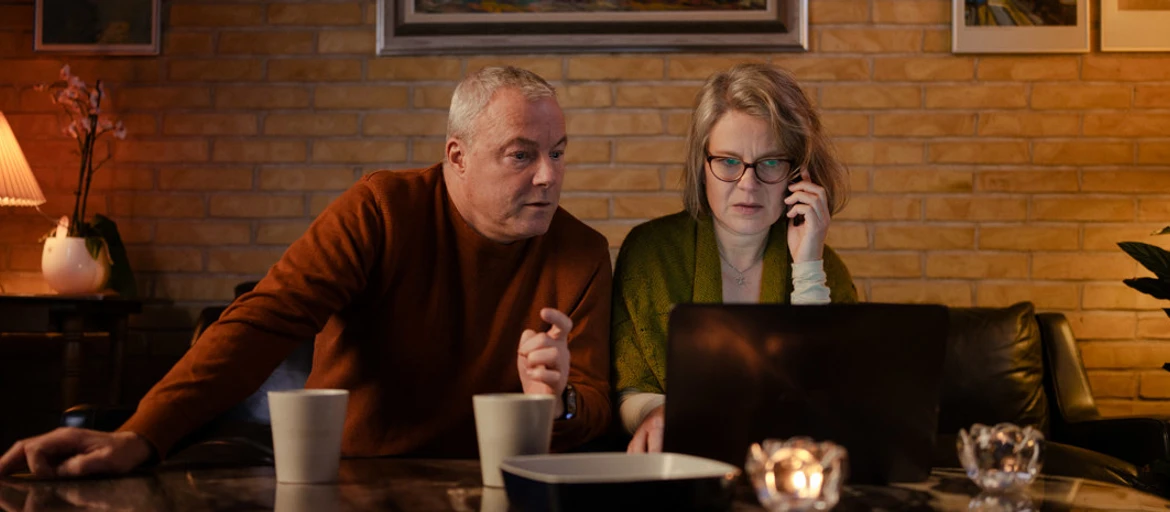 Et ægtepar sidder foran computer og bliver svindlet over telefonen